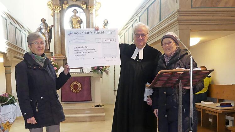 Gundula Rieger und Astrid Morelle übergeben den Spendenscheck an Dekan Günther Werner. Foto: Paul Pöhlmann