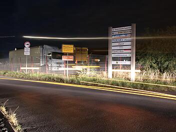 Bei dieser Langzeit-Belichtung erscheinen die Lichter eines in die Frankenstraße fahrenden Lkw als lange Streifen. Jede Nacht werden auf dem Eck-Grundstück zur Kreisstraße Container umgesetzt. Den nachträglichen Antrag dafür stellte der Bauausschuss vorerst zurück.  Foto: Ralf Ruppert