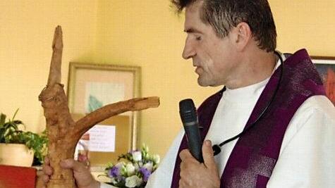 Pfarrer Andreas Hornung und das von Monika Wölfel geschnitzte Kreuz. Letzeres hängt im neuen Sterberaum.  Foto: Petra Malbrich