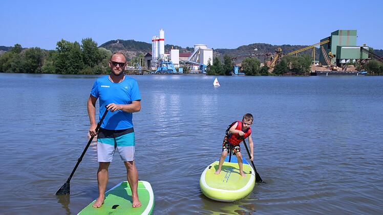 Thomas Kehrberger fährt mit dem jüngsten Paddler Elia auf dem See.