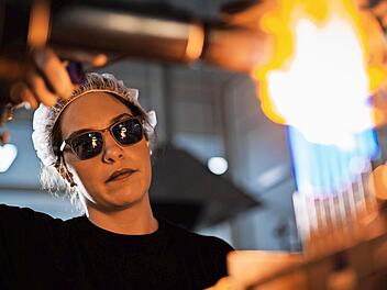 Eine Glasapparatebauerin bei der präzisen Formgebung von Glas bei Siemens Healthineers