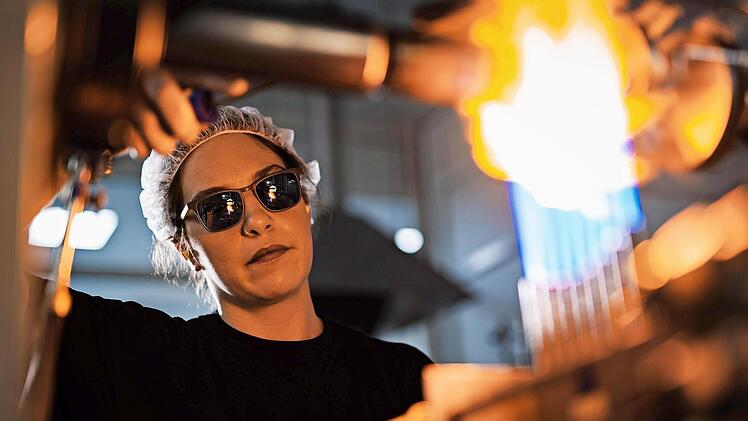 Eine Glasapparatebauerin bei der präzisen Formgebung von Glas bei Siemens Healthineers