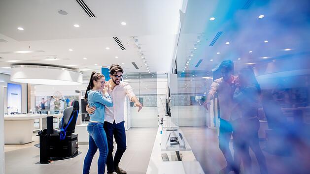 Schn&auml;ppchen, Deal, reduziert, g&uuml;snstig, Man pointing on TV he like. Woman leaning on him.Man pointing on TV he like. Woman leaning on him.  von Dusan Petkovic, TV, Fernseher, Angebot, Technik, Schn&auml;ppchen, Deal