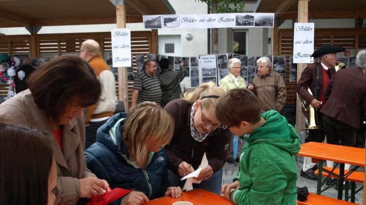 Tim Ströhlein (grüne Jacke) bastelt beim Tisch des Kindergartens ein Windrad.
