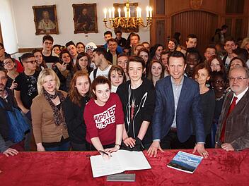 Die Schüler aus Cournon und Ariccia trugen sich in Gegenwart von Bürgermeisters Andreas Hügerich in das Gästebuch ein. Foto: Alfred Thieret
