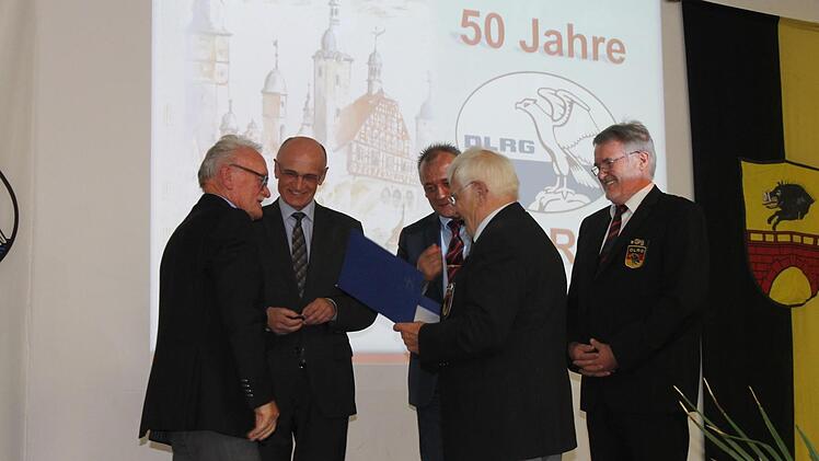 Harald Theuring (links) bekommt vom Ehrenpräsidenten Günther Kolb eine Ehrenurkunde überreicht und von Landrat Wilhelm Schneider das Verdienstzeichen Gold mit Brillant angesteckt.