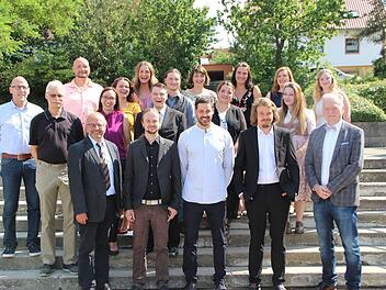 Jens Fuhl (links, Lebenshilfe Rhön-Grabfeld), Thomas Hahn (2. von links) Dominikus Ringeisenwerk Maria Bildhausen), BBZ-Schulleiter Georg Gißler  ( links vorne), Fachschulleiterin Manuela Schlembach (3. von links zweite Reihe) und Helmut Blank (rechts vorne) gratulierten den  Heilerziehungspflegern zum Abschluss ihrer Ausbildung.H. Beudert