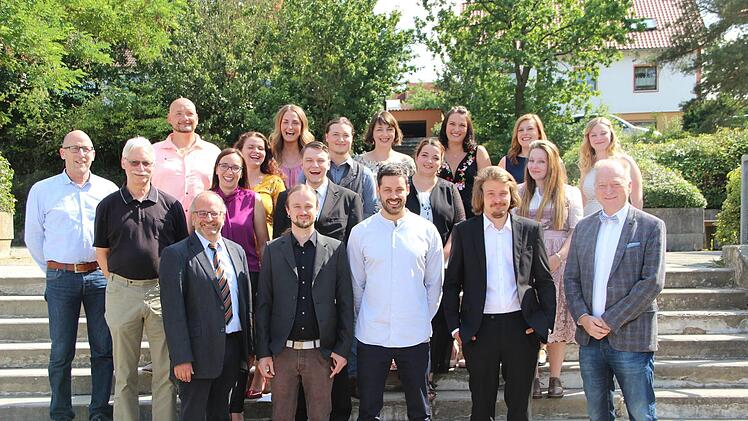 Jens Fuhl (links, Lebenshilfe Rhön-Grabfeld), Thomas Hahn (2. von links) Dominikus Ringeisenwerk Maria Bildhausen), BBZ-Schulleiter Georg Gißler  ( links vorne), Fachschulleiterin Manuela Schlembach (3. von links zweite Reihe) und Helmut Blank (rechts vorne) gratulierten den  Heilerziehungspflegern zum Abschluss ihrer Ausbildung.H. Beudert