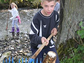 Mit dem Rechen fischte 2014 Max Greim vom Gartenbauverein Kaffeebecher aus dem Bach. Archiv/Sonja Adam