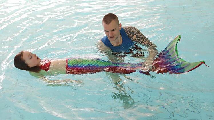 Trainer Oliver zeigt Lara die Schwimmtechnik von Meerjungfrauen geht. Foto: Barbara Herbst