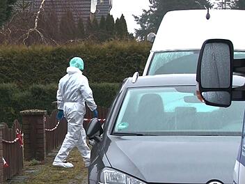 Ein Kriminalpolizist in einem wei&szlig;en Overall geht vor einem Einfamilienhaus zu einem Einsatzfahrzeug. Eine junge Frau ist umgebracht worden. Nach dem Hinweis eines Mannes auf eine tote Frau in einem Wohnhaus entdeckten Beamte den Leichnam in der Nacht zum 22.03.2018. Foto: TNN/dpa
