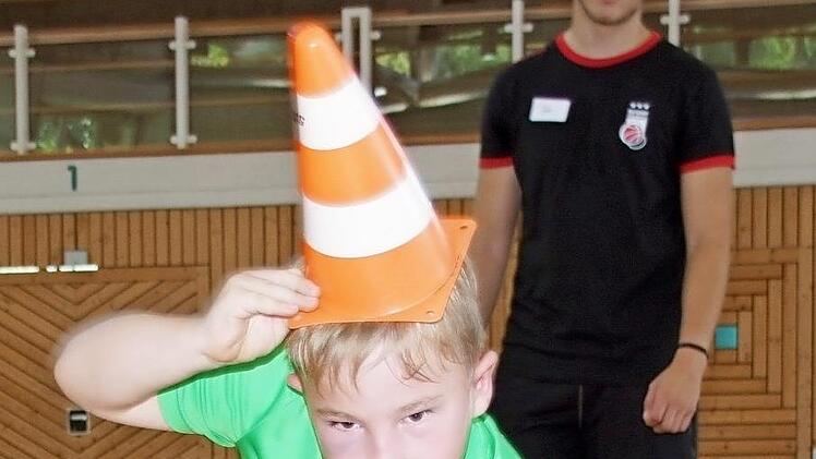 Hannes rollt mit Hütchen auf dem Kopf den Ball gerade zum Ziel.