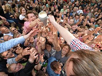 OB Florian Janik (SPD) verteilt beim Anstich des ersten Fasses auf der 260. Bergkirchweih in Erlangen Maßkrüge mit Bergbier. Zwölf Tage bsi einschließlich Montag 1. Juni wird am Burgberg gefeiert. Die Studentenstadt Erlangen erwartet auch im Jahr 2015 zum Berg wieder rund eine Million Besucher. Foto: Ronald Rinklef