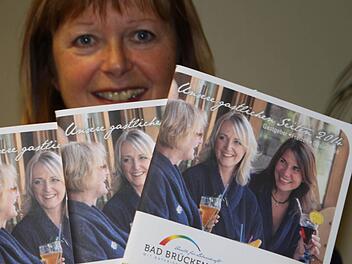 Karin Bauer von der Tourist-Info präsentiert das neue Gastgeberverzeichnis. Die drei Damen auf dem Titel lassen es sich offensichtlich gut gehen. Foto: Ulrike Müller