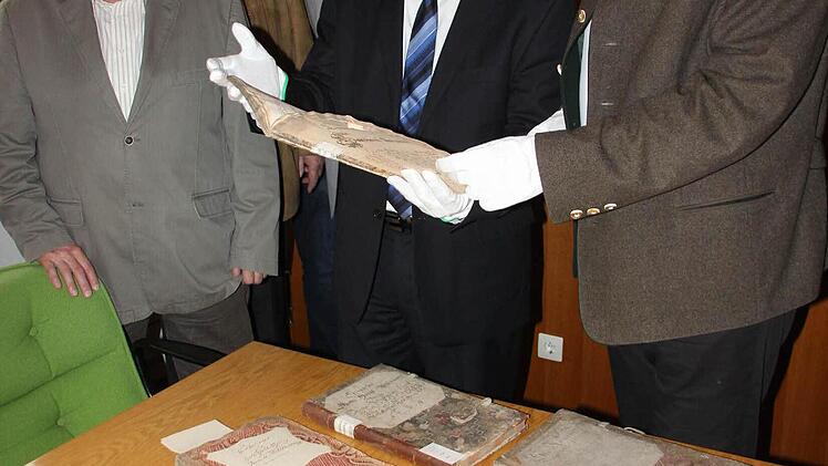 Die alten Bände muss man mit Schutzhandschuhen anfassen, um sie nicht zu beschädigen. Das Bild zeigt (von links): Hermann Wich, Wolfgang Simon, Stefan Wicklein, Elmar Kerner, Wolfgang Beiergrößlein und Thomas Teuchgräber. Fotos: Friedwald Schedel