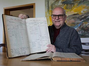 Anton Schick Senior mit einem alten, handgeschriebenen Auftragsbuch aus der Bauzeit des Kurhausbades. Foto: Benedikt Borst