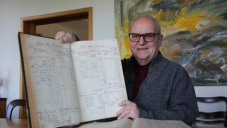 Anton Schick Senior mit einem alten, handgeschriebenen Auftragsbuch aus der Bauzeit des Kurhausbades. Foto: Benedikt Borst