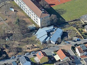 Das Gebäude mit dem grauen Dach ist der Kinderhort, der soll in Richtung Wiese (rechts davon) expandieren. Luftbild: Ronald Rinklef