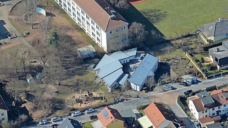 Das Gebäude mit dem grauen Dach ist der Kinderhort, der soll in Richtung Wiese (rechts davon) expandieren. Luftbild: Ronald Rinklef