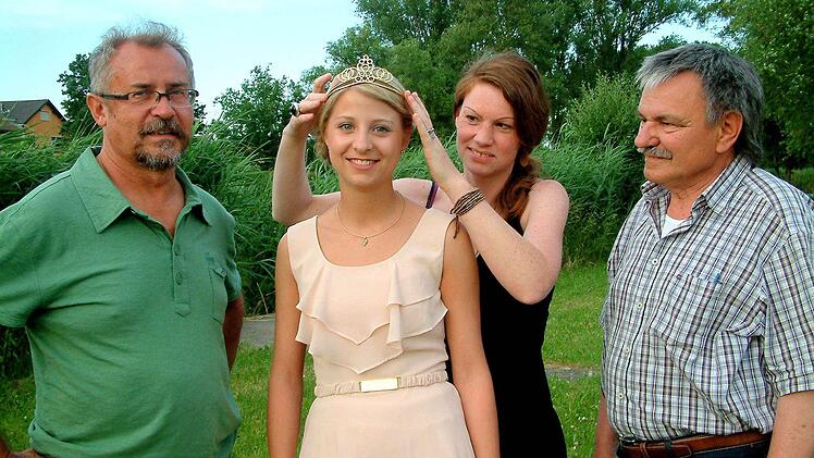 Goldschmiedin Katja Bulheller passt Weinprinzessin Isabel Bergmann das neue Krönchen an. Die Weinfest-Organisatoren Roland Mahr (links) und Ernst Albert sind mit dem Werk sehr zufrieden. Foto: ab