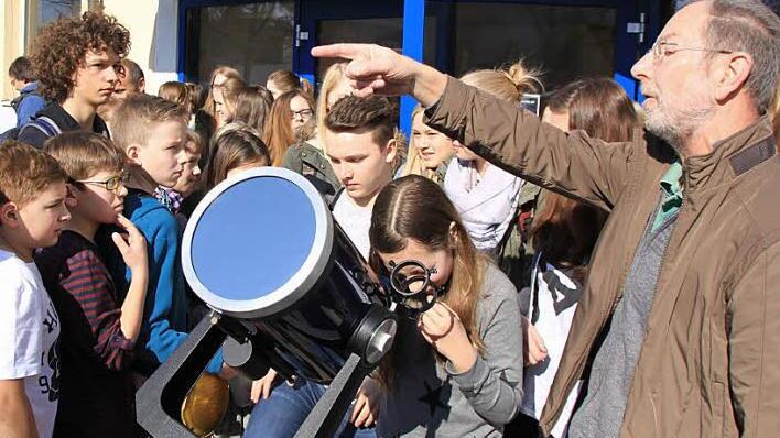 Die Gymnasiasten stehen Schlange, um durch das 20-Zentimeter-Spiegelteleskop einen Blick auf die beiden Himmelskörper zu werfen. Alfred Förner erklärt ihnen, was am Firmament vorgeht. Fotos: Matthias Einwag