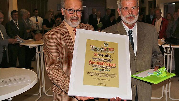 Bürgermeister August Weingart (l.) überreicht seinem Amtsvorgänger Konrad Weingart die Ernennungsurkunde zum Altbürgermeister von Sulzthal.