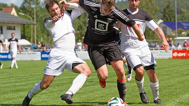 Zwischen den Redwitzern Florian Goller und Christian Goller (weiß) sucht der Gästeangreifer Hannes Küfner einen Ausweg.