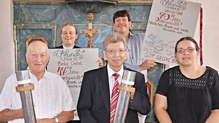 Über Jahrzehnte ließen Werner Grell und Dieter Oehrl (vorne, von links) viele Orgelpfeifen erklingen. Eine mit dem Grundton "a" durften sie bei ihrer Verabschiedung mitnehmen; rechts die Nachfolgerin auf dem Orgelbock, Rebekka Fischer aus Rentweinsdorf. Pfarrerin Sonja von Aschen und Dekanatskantor Matthias Brüggemann dankten für den Einsatz der Orgelspieler.  Foto: Helmut Will