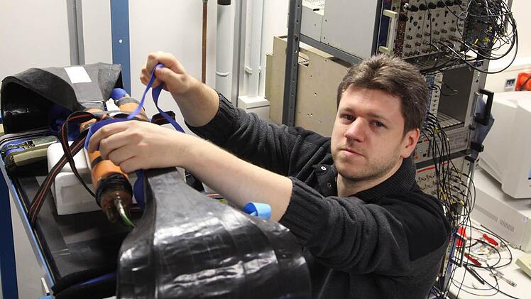 Martin Krapp arbeitet an einem Praktikumsversuch für Physikstudenten. Dabei wird die so genannte kosmische Höhenstrahlung nachgewiesen. Genauer gesagt werden dabei instabile Teilchen namens Myonen gemessen, die hauptsächlich in der Hochatmosphäre der Erde entstehen und bis auf die Erdoberfläche kommen können.  Foto: Georg Pöhlein