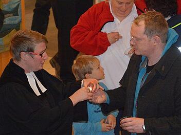 Zu einem Blaulichtgottesdienst gehört es, dass die Teilnehmerinnen und Teilnehmer beim Vater unser Kerzen in den Händen halten und diese danach vor dem Altar abstellen. Foto: Hanns Friedrich