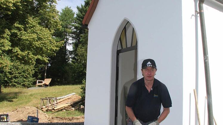 Matthias Weigel passt die Pflastersteine an und sorgt mit anderen Helfern dafür, dass der Platz vor der Kapelle schön eben wird.