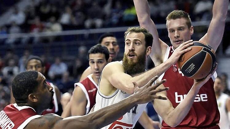 Brad Wanamaker (l.) und Leon Radosevic nehmen Sergio Rodriguez in die Zange. In der zweiten Hälfte drehte der Real-Star dann aber auf und rettete seiner Mannschaft den Sieg. Foto: dpa