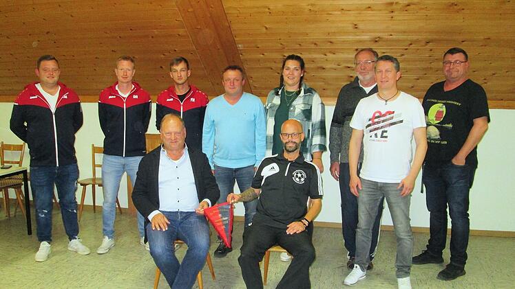Der scheidende Vorsitzende Gerald Meder übergab seine Aufgaben symbolisch mit dem Vereinswimpel an Tino Reuter (sitzend von links). Den Gesamtvorstand ergänzen (hintere Reihe von links) Lukas Meder, David Reuter, Florian Holzinger, Peter Holzinger, Bianca Ohmann, Dirk Dallmann, Marko Hofmann und Matthias Reith.