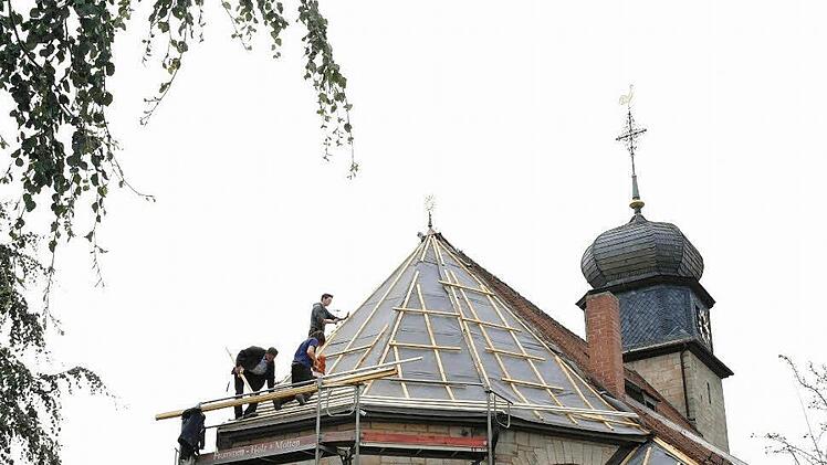 Handwerker dichten das Kirchendach ab und schützen es so vor Wind und Regen. Fotos: Stepahnie Elm/ Bernhard Kretz