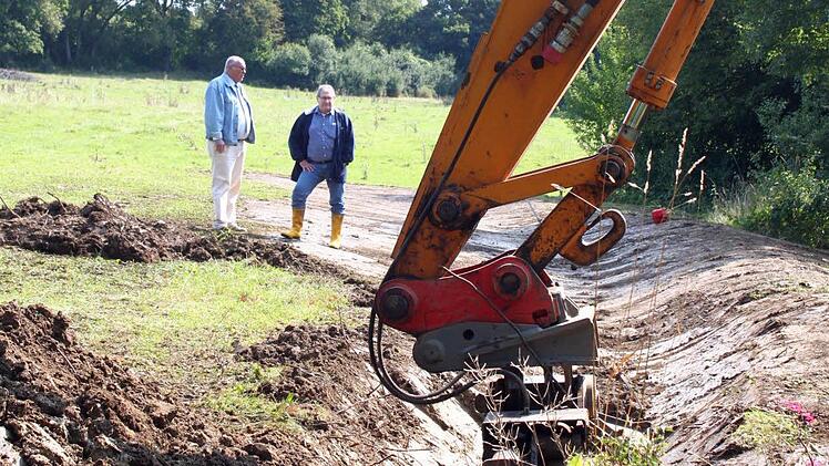 Bürgermeister Dieter Adam (links) und Ingenieur Dieter Wagner begutachten die vom Bagger geformte Erdmulde. Sie soll das Regenwasser von der Wohnbebauung im Steinloch abhalten und kontrolliert abführen.  Fotos: Jochen Nützel