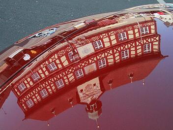 Das Rathaus im Spiegel einer Motorhaube: Der Staffelsteiner Stadtkern wird zu einem ganz großen Autohaus. Foto: Matthias Einwag