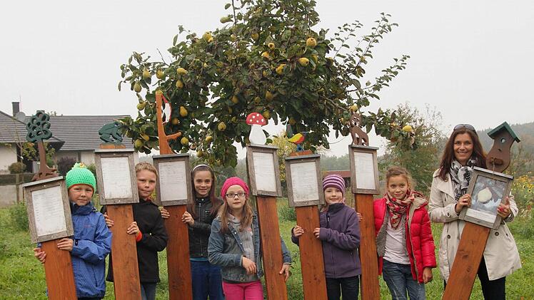 Stolz zeigen die Schüler mit Rektorin Antje Schorn (rechts) ihre Hinweistafeln unter der Quitte.Foto: Günther Geiling
