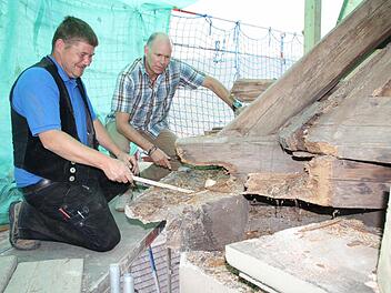 Zimmerer Marko Fischer (von links) und Architekt Henry Kiesel begutachten die Schäden im Dachstuhl. Gerade am Gesims und an Knotenpunkten muss jede Menge Holz ausgetauscht werden. Fotos: Ralf Ruppert