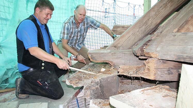 Zimmerer Marko Fischer (von links) und Architekt Henry Kiesel begutachten die Schäden im Dachstuhl. Gerade am Gesims und an Knotenpunkten muss jede Menge Holz ausgetauscht werden. Fotos: Ralf Ruppert