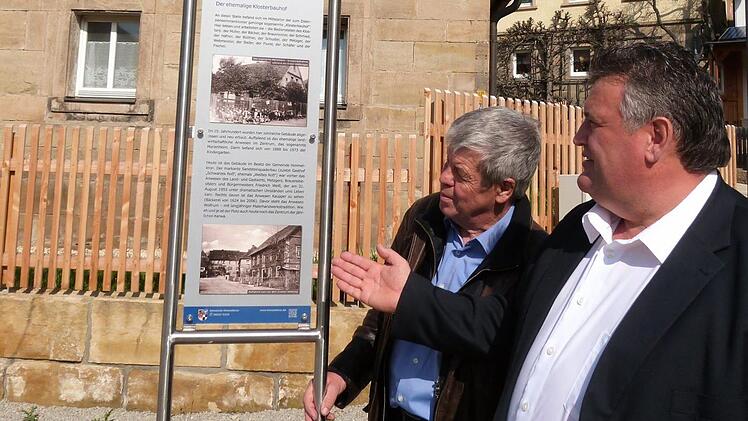 Bürgermeister Gerhard Schneider (rechts) steht zusammen mit Erwin Tischer an der Hinweistafel 5 "Der ehemalige Klosterbauhof". Foto: Werner Reißaus