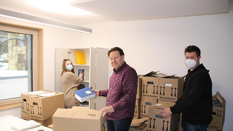 Geschäftsleiter Michael Unsleber (Mitte) räumt mit der Auszubildenden Theresa Kaiser (links) und Fabian Hollmeyer aus der Personalstelle erste Umzugskartons in seinem neuen Büro in der Hammelburger Straße aus. Ralf Ruppert
