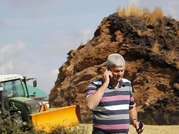 Hermann Greif ist ständig am Mobiltelefon. Früher musste der Landwirt aus Pinzberg melken, heute muss er managen. Neben seiner Biogas-Anlage wachsen die Maisberge in den Himmel.   Fotos: Nikolas Pelke