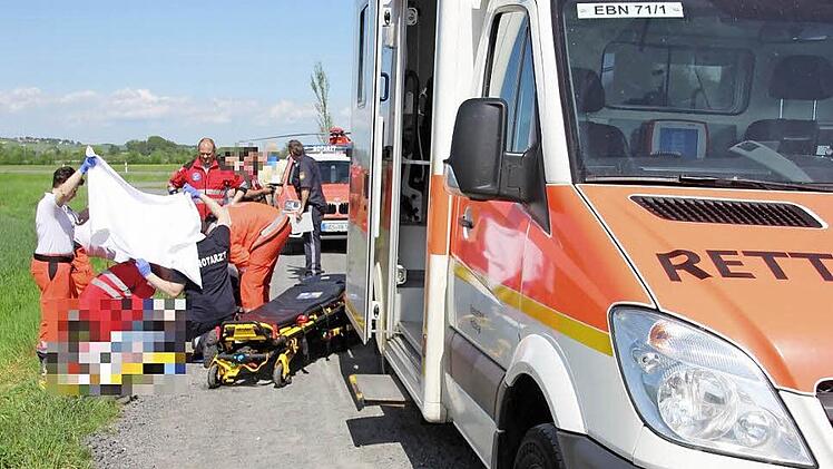 Notärzte und Sanitäter kümmerten sich um den Mann, nachdem er sich am Vatertag im Mai 2015 auf einem Schotterweg Richtung Recheldorf (Gemeinde Untermerzbach) schwer verletzt hatte. Sogar ein Rettungshubschrauber (im Hintergrund zu erkennen) war angefordert worden, wurde aber letztlich nicht benötigt. Das Geschehen wurde jetzt vor dem Amtsgericht in Haßfurt aufgearbeitet. Foto: Ralf Kestel/Archiv