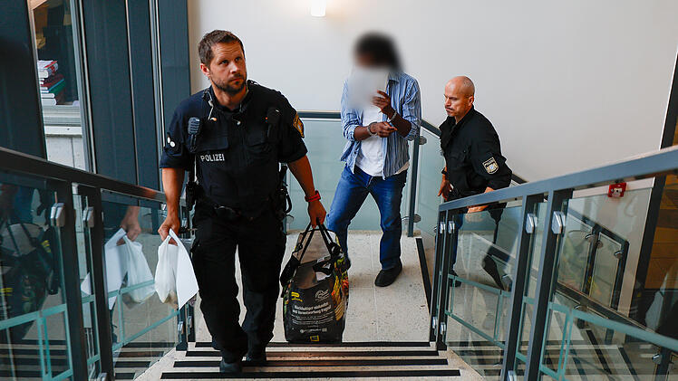 Der Angeklagte wird von der Polizei in Handschellen zum Gerichtssaal, im Landgericht Aschaffenburg gebracht.