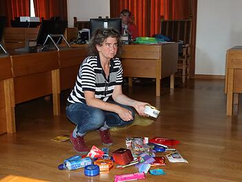 Ulrike Hartmann-Mitz schüttet Produktverpackungen aus: Bei allen steht Palmöl in der Zutatenliste.