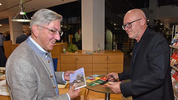 Gerne signierte der Autor Roman Rausch (rechts) bei der Eröffnung des 2. Literaturfestivals Haßfurt in der Sparkassengalerie in Haßfurt seine Bücher. Darüber freute sich Dr. Volker Grumbach (links).