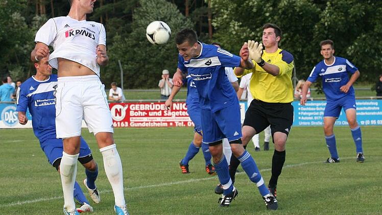 Der Sander Maximilian  Göbhardt (links vorne, weißes Trikot) hat sich für die Partie bei seinem ehemaligen Verein in Memmelsdorf sicher besonders viel vorgenommen.