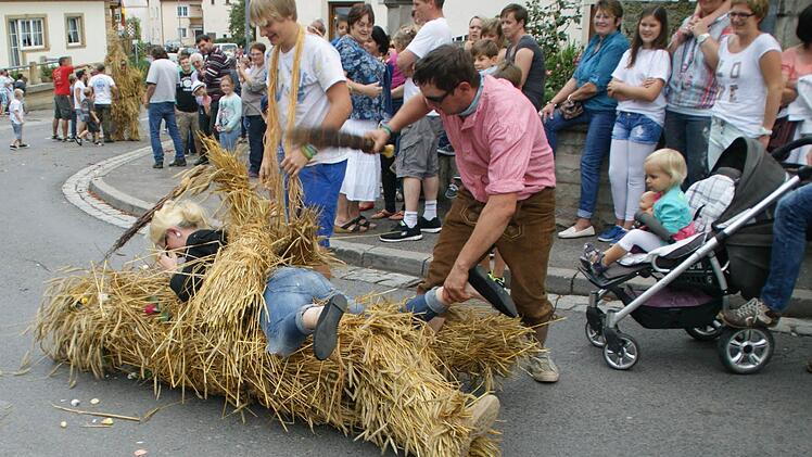 Kaum von der Kapelle zum Dorfplatz geleitet, gingen die Strohbären auch schon auf die Suche nach jungen Damen, die sie zu Boden reißen konnten.