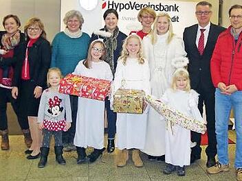 Die Hypo-Vereinsbank Kronach initiierte erneut eine Wunschbaum-Aktion. Das Bild zeigt (von links) Anna See, Elisabeth Fischer, Birgit Weickert, Zweite B&uuml;rgermeisterin Angela Hofmann, Irene Piontek, "Christkind" Melissa D&ouml;rfer mit ihren drei Engeln, Ralf Baumann und Oliver See. Mit auf dem Bild sind die Kinder des Ehepaares See. Foto: H. Sch&uuml;lein