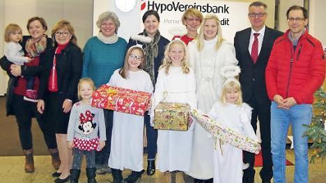Die Hypo-Vereinsbank Kronach initiierte erneut eine Wunschbaum-Aktion. Das Bild zeigt (von links) Anna See, Elisabeth Fischer, Birgit Weickert, Zweite B&uuml;rgermeisterin Angela Hofmann, Irene Piontek, "Christkind" Melissa D&ouml;rfer mit ihren drei Engeln, Ralf Baumann und Oliver See. Mit auf dem Bild sind die Kinder des Ehepaares See. Foto: H. Sch&uuml;lein